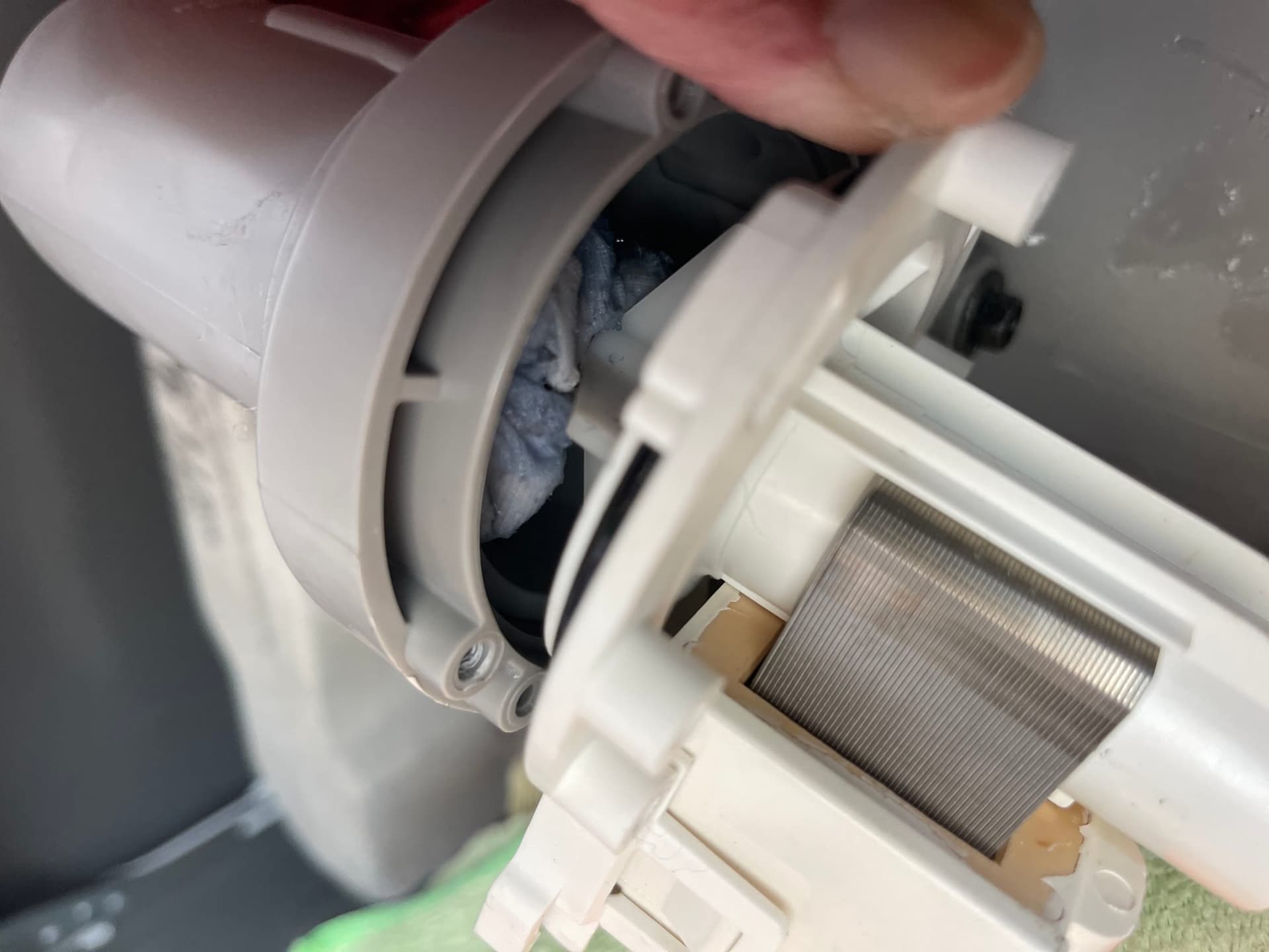 A blocked washing machine drain being cleared during a service.